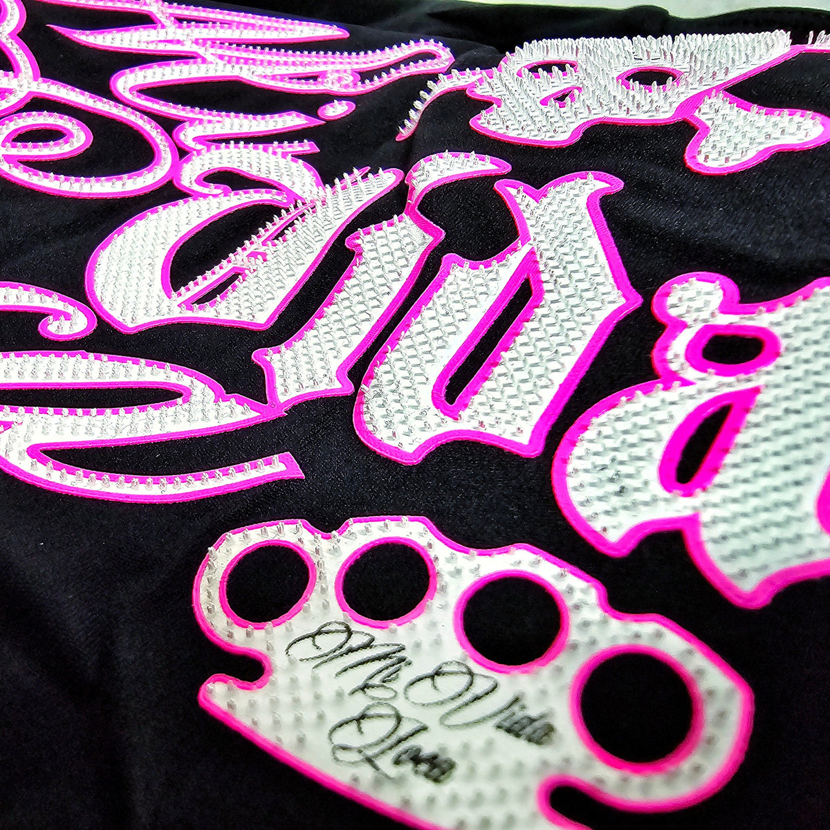 Gros plan de l'imprimé Babe Skull rose et blanc avec logo MVL sur le top noir