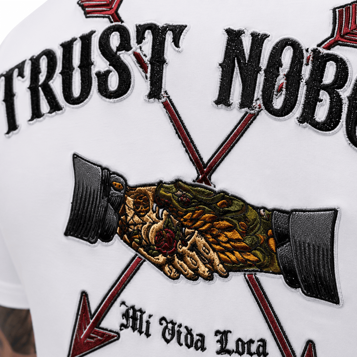 Nahaufnahme der Trust nobody Stickerei auf dem Rücken: Handschlag zwischen zwei Pfeilen mit Mi Vida Loca Schriftzug