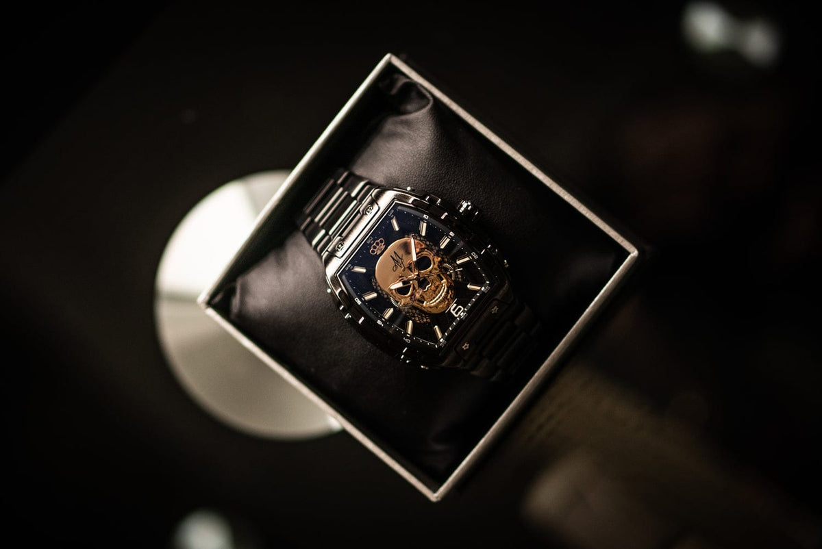 MVL Automatic skull watch schwarz/schwarz in der offenen Geschenkbox, von oben in dunkler Umgebung
