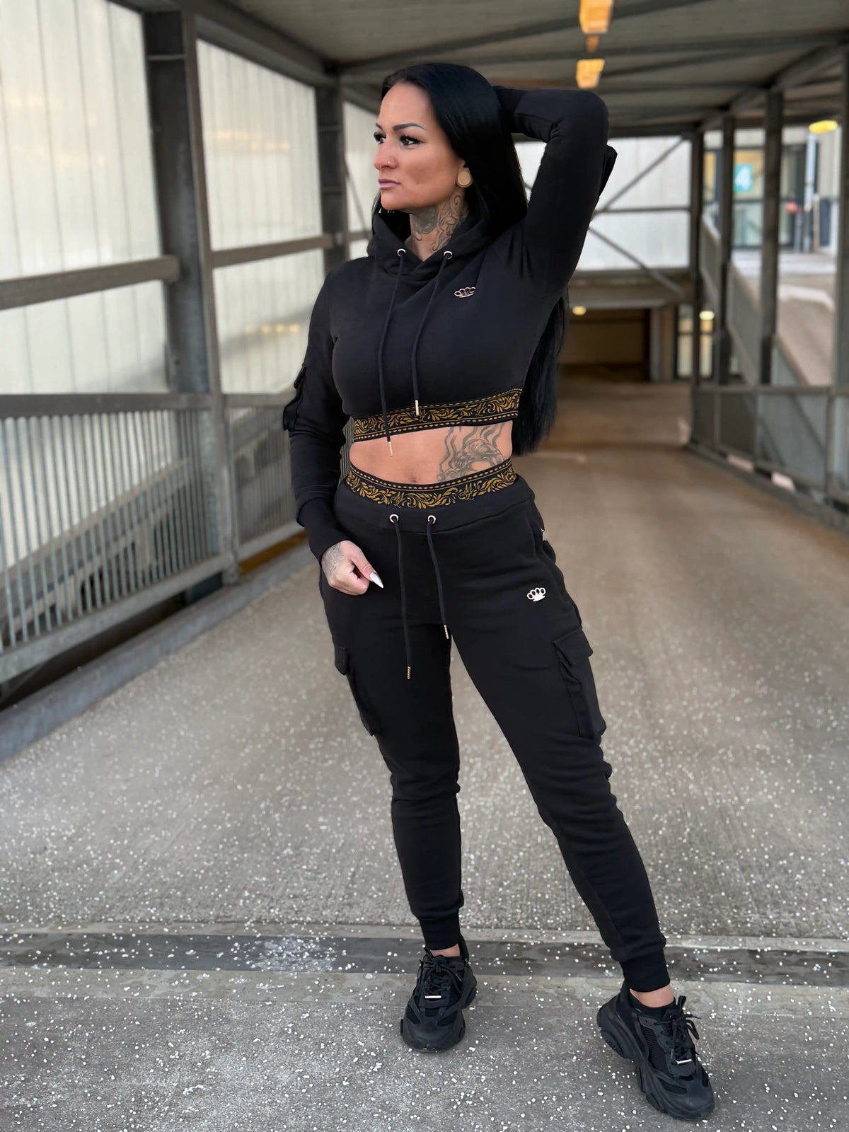 Mannequin dans le survêtement femme MVL Meander noir avec hoodie court sur une passerelle