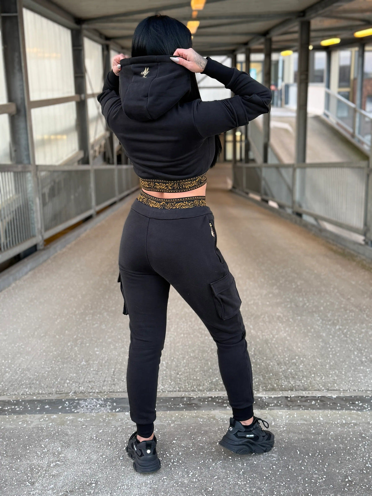 Mannequin montrant le dos du survêtement femme MVL Meander, mains sur la capuche