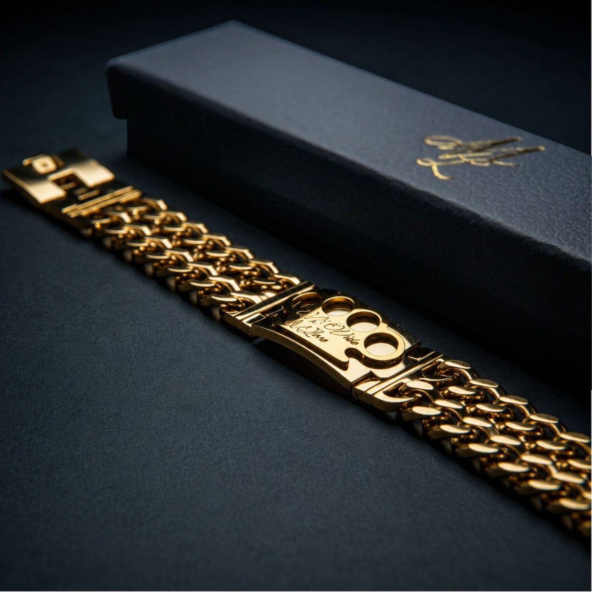 Bracelet Mi Vida Loca MVL doré, plaqué or 18 carats, avec plaque logo MVL à côté du coffret cadeau noir