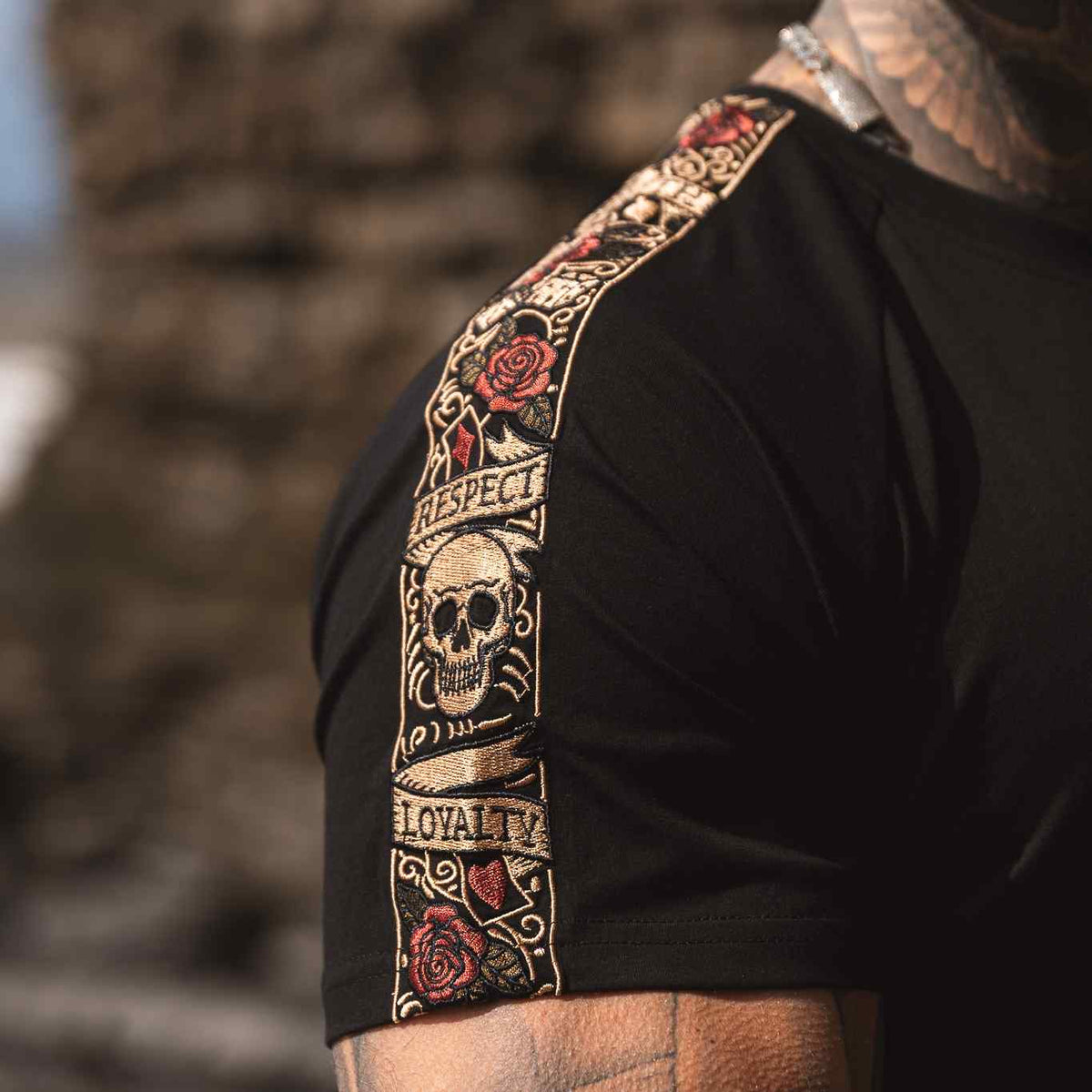 Nahaufnahme des LFR Stickbands mit Totenkopf, Rosen und Schriftzug Respect und Loyalty am Ärmel