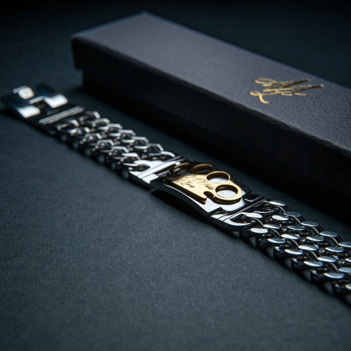 Mi Vida Loca MVL armband zilver met gouden MVL logo-plaat naast de zwarte geschenkdoos