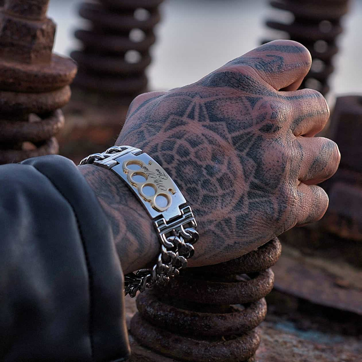 MVL armband zilver/goud om een getatoeëerde hand op roestige metalen spiralen
