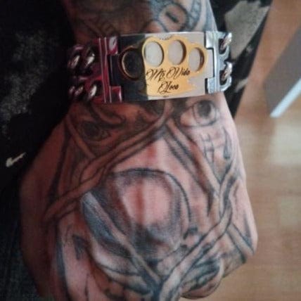 Close-up van de MVL armband met gouden MVL logo en Mi Vida Loca gravure op de pols