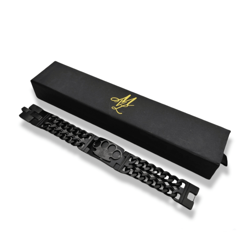 Schwarzes MVL Black line Armband mit Gliederkette vor der geschlossenen Box mit goldenem Logo