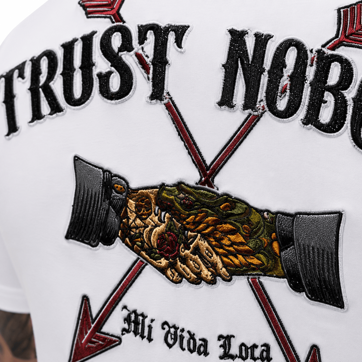Camiseta blanca con el bordado «No confíes en nadie»
